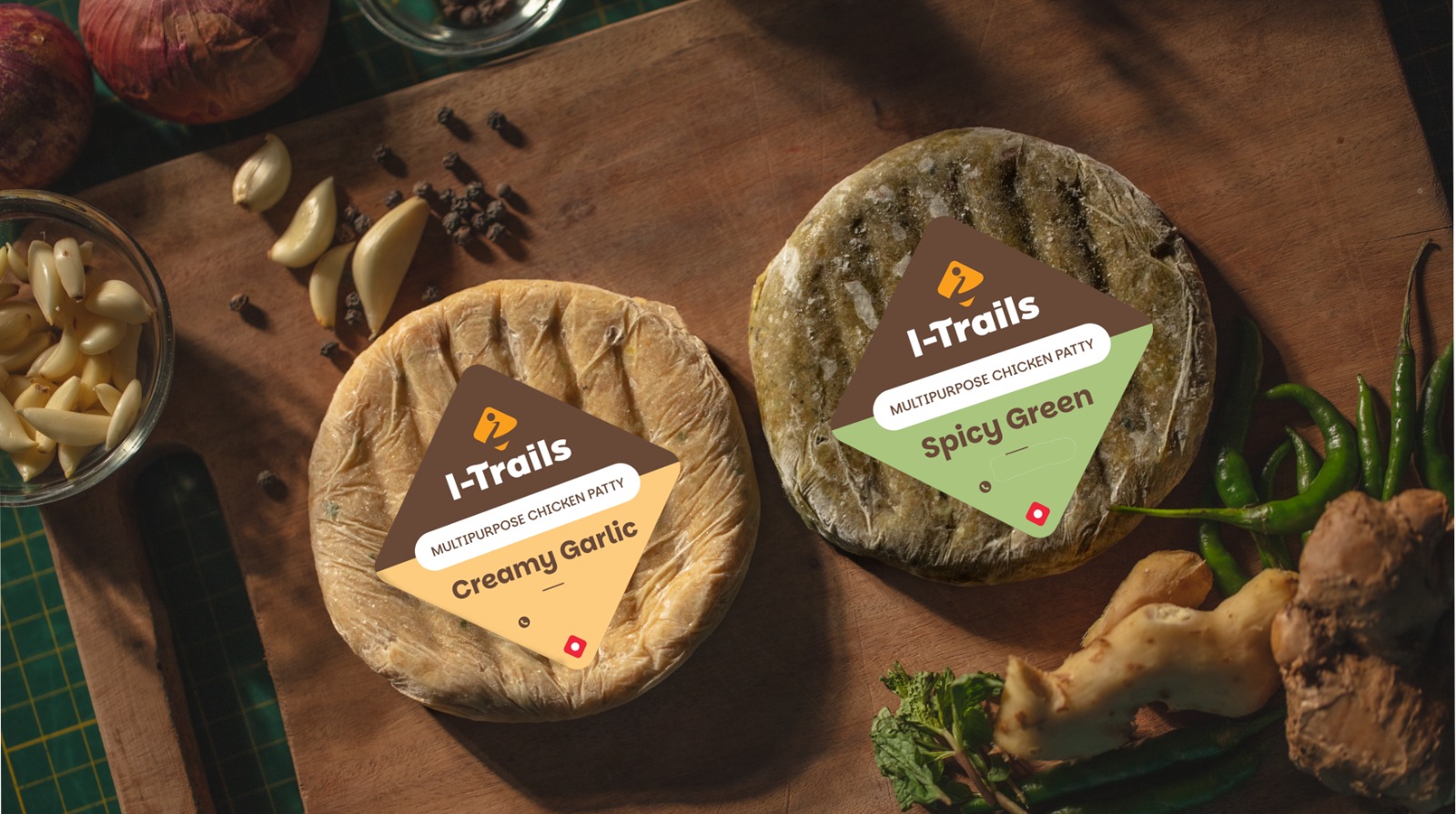 I-TRAILS Creamy Garlic and Spicy Green chicken patties on a wooden board with garlic, chillies and spices